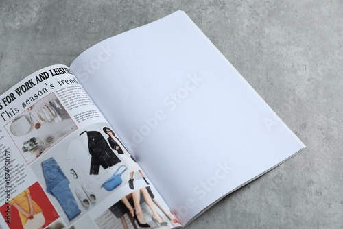 Open magazine on grey table, above view. Mockup for design