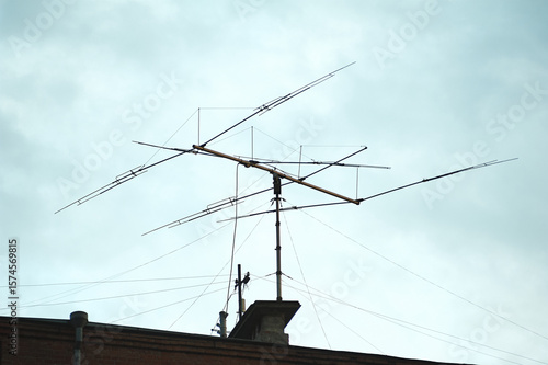 Old big antenna on the roof of a brick house against the sky, in the city