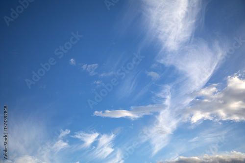 White cirrus clouds against a blue summer sky