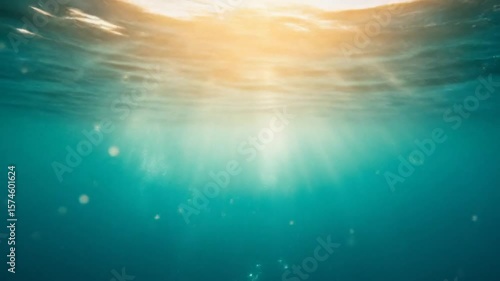 Soft sunlight penetrates the surface of tropical waters. Peaceful marine scene with tranquil ambiance below sea level.