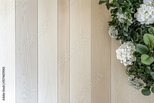 Light beige wooden planks with white flowers and greenery.