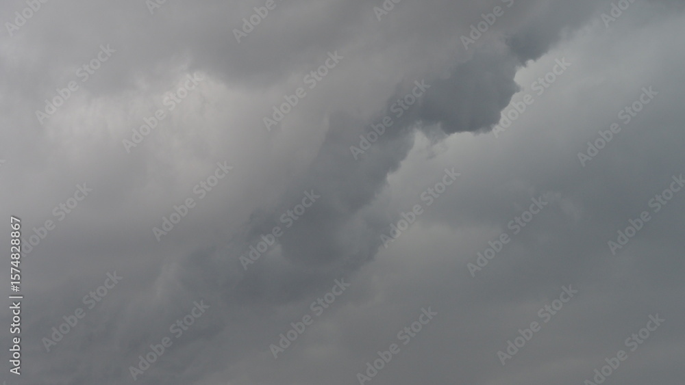Dramatic storm clouds blanket the mountain peaks, casting a dark and moody atmosphere over the blue sky Dramatic storm clouds blanket the mountain peaks, casting a dark and moody atmosphere over the blue sky