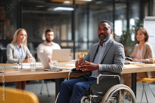 Confident charismatic businessman in a wheelchair expertly leads a productive team meeting
