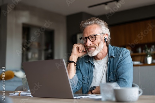 Mature Man Working From Home on Laptop Relaxed and Focused
