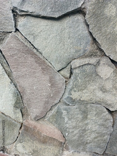 Close-up of rough rock wall structure made from slate stone, great for natural background, geology illustration, and interior material reference
