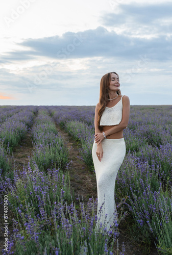 An Elegant Woman Posing Gracefully in a Lavender Field During the Beautiful Sunset Hour