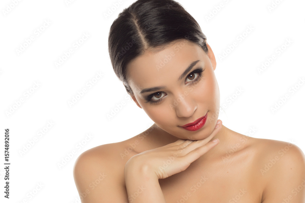 Studio shot on white background of elegant woman posing with chin resting on hand, looking down Studio shot on white background of elegant woman posing with chin resting on hand, looking down