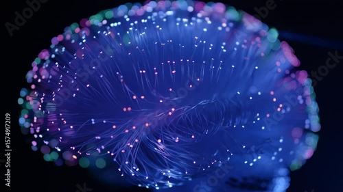 Looping animation of brain formed from tangled glowing fiber-optic threads with data pulses traveling along each thread independently

