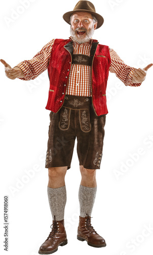 Tableau sur toile Senior man in traditional Bavarian costume with red vest brown lederhosen and hat standing against white background