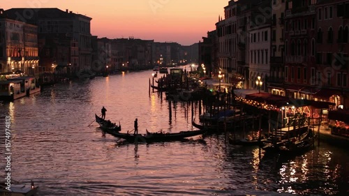 Gondolas glide along the grand canal in venice at twilight