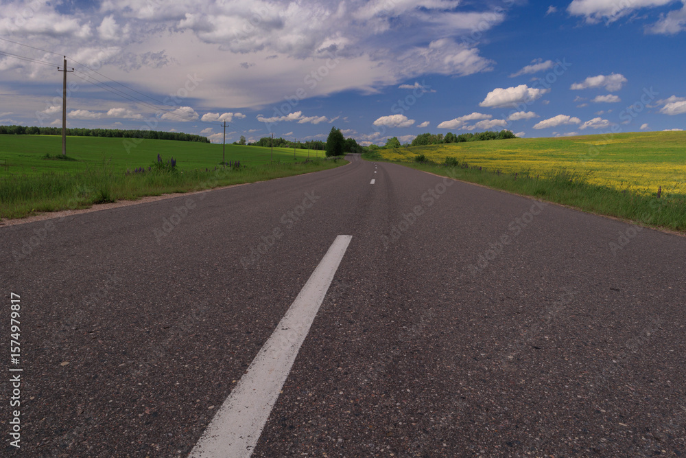 Fototapeta premium Highway wide road, transport and blue sky with clouds on a summer day