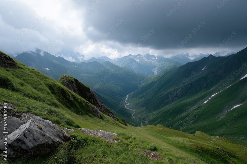Obraz premium Dramatic cloudy sky over lush green mountain valley panorama