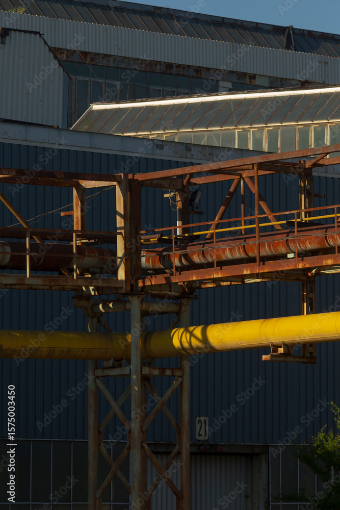 Naklejka premium There is a large building that has a significant number of pipes prominently located in front of it, possibly for various functions or utilities