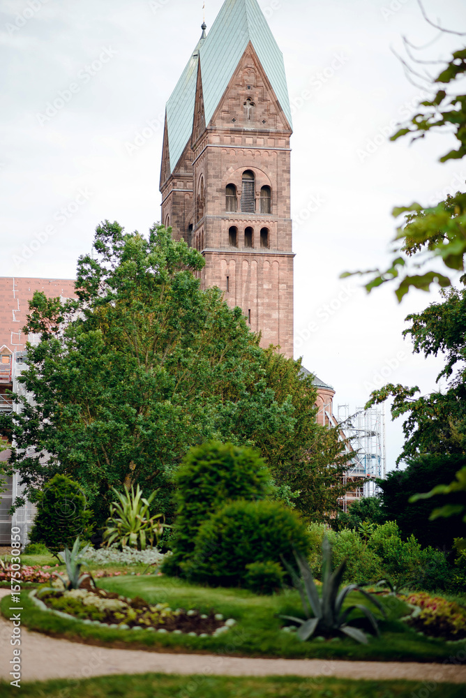 Fototapeta premium Historic Tower Surrounded by Lush Garden
