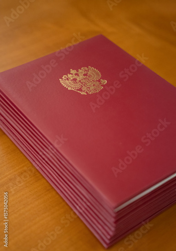 An Elegant Red Bound Volume Displayed with a Golden Emblem on a Beautiful Wooden Table