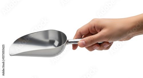 A hand holding a shiny metal scoop with a cylindrical handle against a dark black background plain backdrop