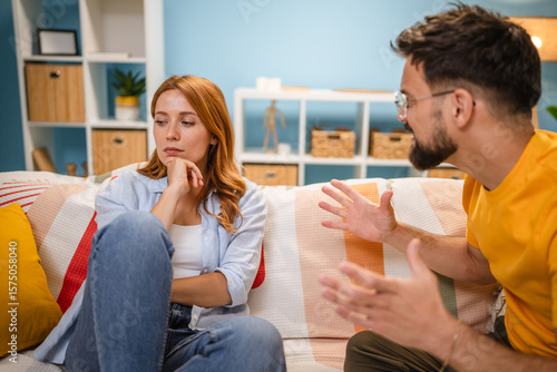Photos Caucasian stressed couple sitting on couch, arguing at home.