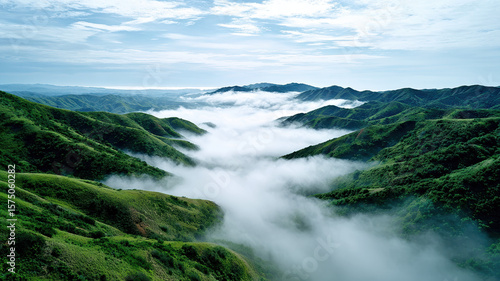 Lush green mountain valley rolling hills dense fog dramatic sky tranquil morning nature landscape misty atmosphere peaceful scenic view outdoor wilderness