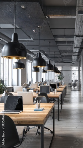 A long view of an open office space with wooden desks and hanging pendant lights in a modern style