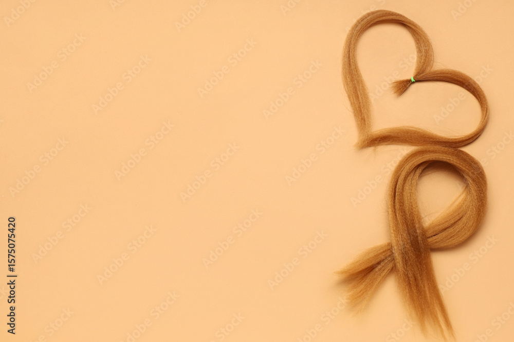 Fototapeta premium Red hair strands for donation on orange background