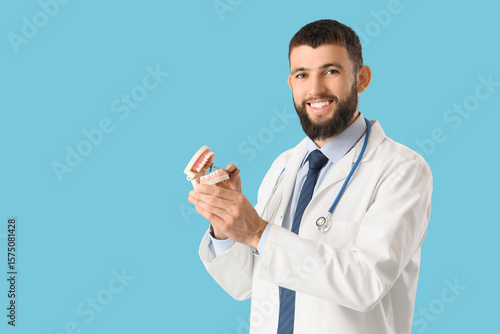 Happy male dentist with pla...