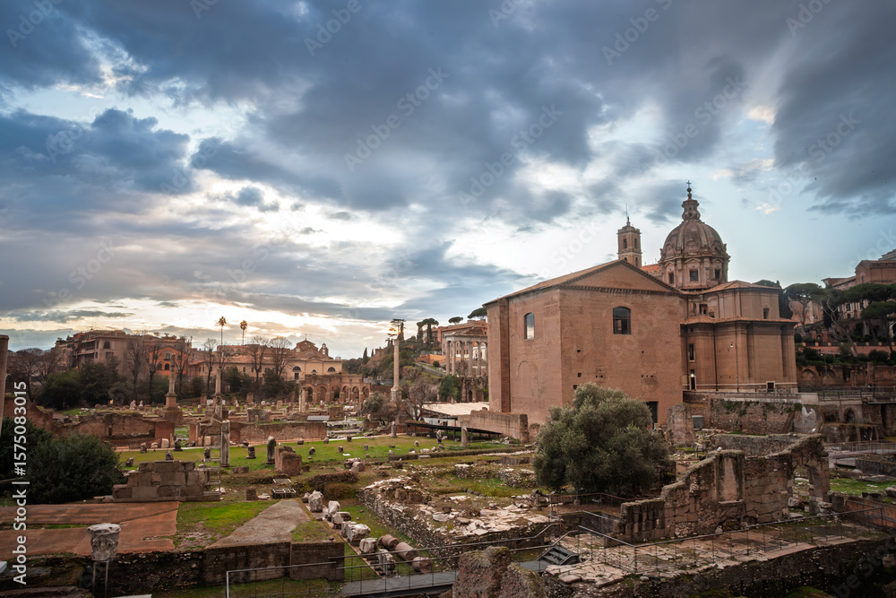 Obraz premium Sunset colours wash the Roman Forum, scattered columns and the church of Santi Luca e Martina rising above lawns and marble fragments that mark the political heart of ancient Rome, italy.