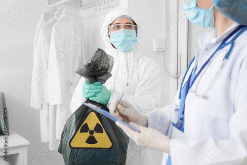 Ταπετσαρία Workers in protective uniforms and with bag of radioactive waste in clinic