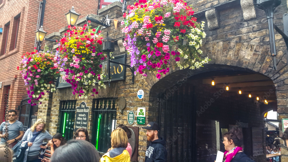 Naklejka premium Colorful hanging flowers over the entrance of a traditional Irish pub, The Brazen Head