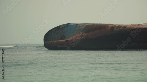 Wide shot of abandoned ship at the ocean of Pantai Pasir Putih or White Sand Beach in Pantai Barat Pangandaran, West Java, Indonesia.