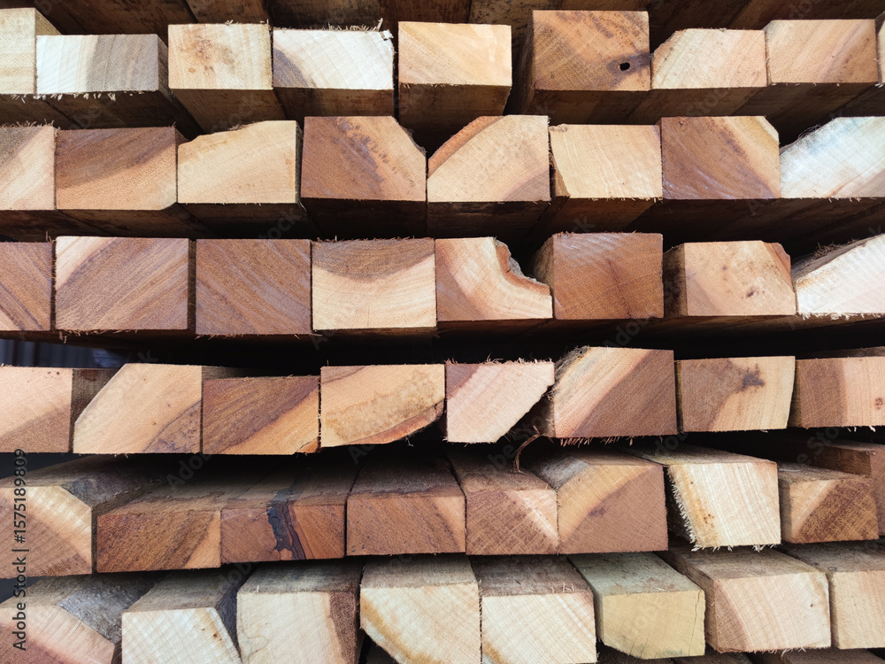 A close-up image of stacked wooden planks with visible natural grain and texture. The timber beams are arranged in a pattern, showcasing the raw and unfinished state of the wood A close-up image of stacked wooden planks with visible natural grain and texture. The timber beams are arranged in a pattern, showcasing the raw and unfinished state of the wood