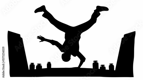 Silhouette of a breakdancer performing a handstand on a ledge with containers and angled supports