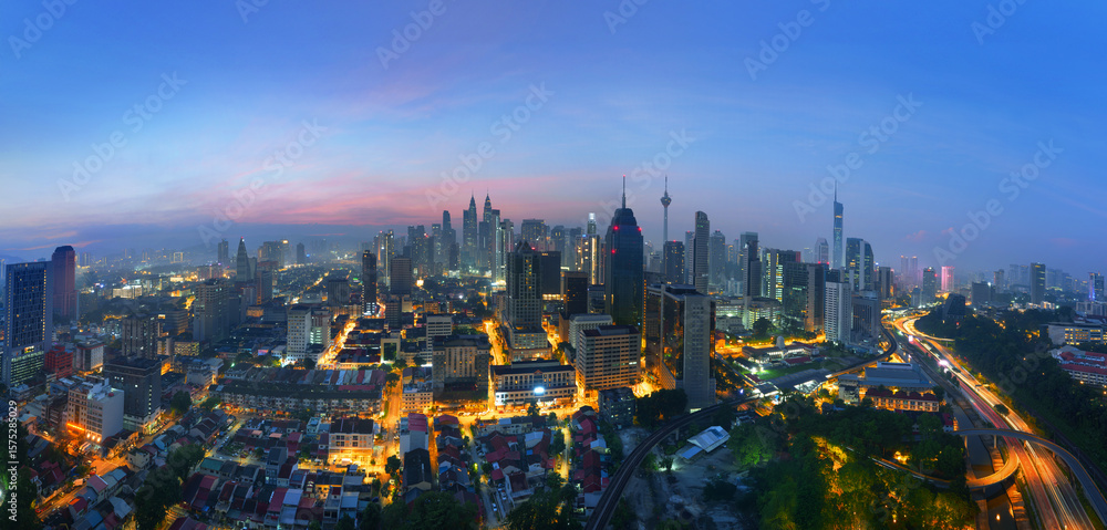 Fototapeta premium Beautiful Sunrise Panoramic View of Kuala Lumpur City Skyline with Skyscrapers and Glowing City Lights.
