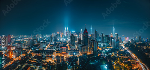 Stunning Night Panoramic View of Kuala Lumpur City Skyline with Illuminated Skyscrapers and Light Trails.