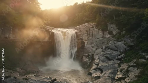 Wallpaper Mural waterfall clip - Majestic waterfall cascading down rocky cliffs surrounded by lush greenery, with sunlight filtering through trees, creating a serene and tranquil atmosphere in nature Torontodigital.ca