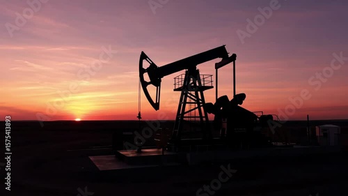 Silhouette Pumping Jack Against Vibrant Sunset Sky