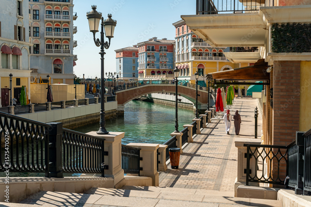 Obraz premium Doha, Qatar: Colorful waterfront shops, cafes and residential apartments line Venice-inspired canals on the manmade Pearl Island in Doha Qatar.