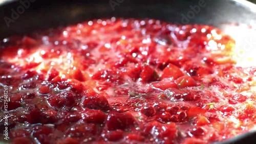 Strawberry boiled in a pan, making homemade strawberry jam