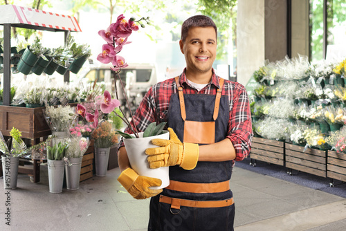 Billede på lærred Gardener holding an orchid in a pot