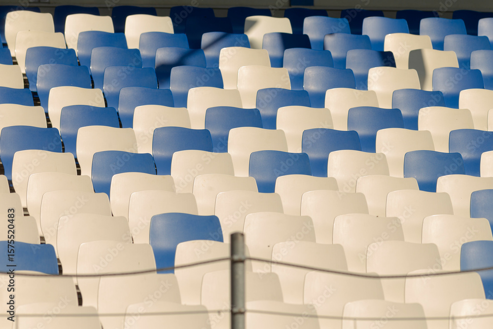 Obraz premium Rows upon rows of blue and white seats can be found in a large stadium, showcasing a vibrant sports venue atmosphere filled with excitement