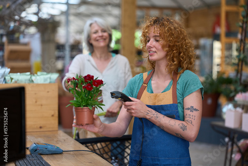 Photography Florist scanning red carnations in flower shop during purchase