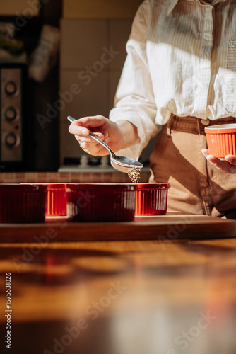 Sprinkling sugar on top of crème brûlée