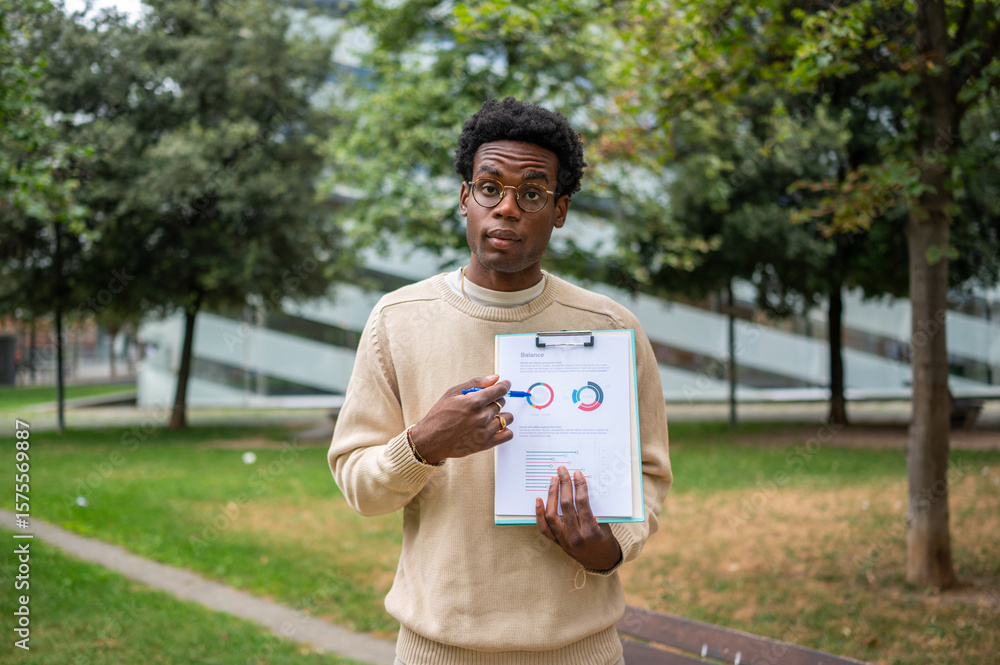 Fototapeta premium Analyst showcasing charts on clipboard in a park