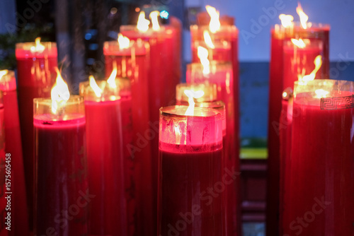 Giant red candles glow brightly in a temple during Chinese New Year and Cap Go Meh celebrations, symbolizing hope and prosperity.