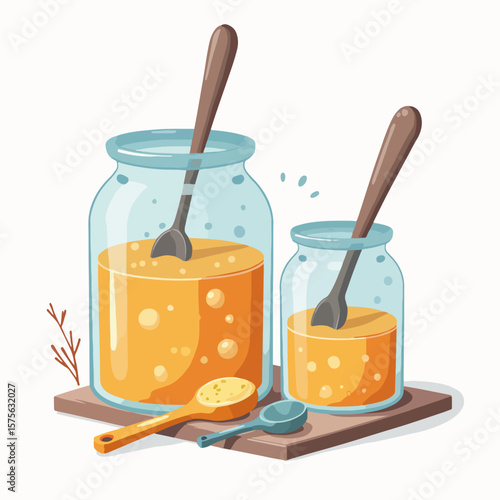 Fermentation jars beside measuring spoons containing homemade brews sit on a wooden board. Scene with fermentation jars shows clear vessels with liquid bubbling, beside filled measuring spoons.
