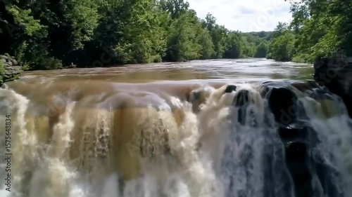 Scenic Waterfall Cascading Down Rocks Surrounded By Lush Greenery