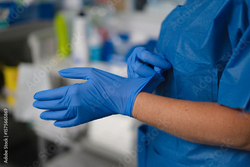 Tableau sur toile Doctor wearing blue sterile gloves in hospital room or laboratory