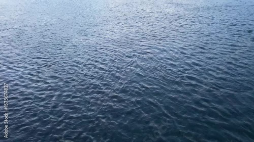 A continuous shot of vibrant blue water with gentle ripples spreading across its surface.
