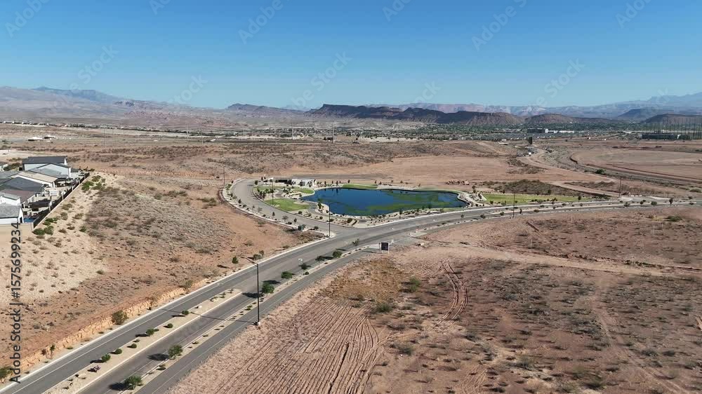 desert landscape featuring a road, lake, houses, highway, and distant mountains. desert landscape featuring a road, lake, houses, highway, and distant mountains.