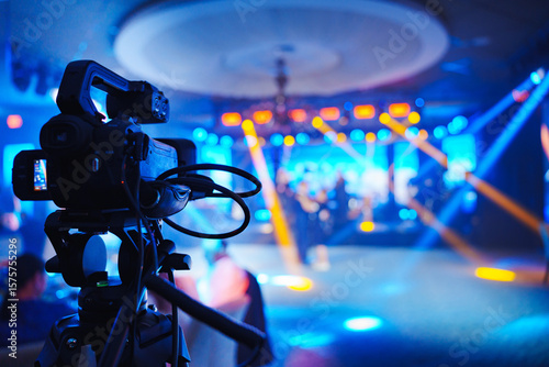 A professional videographer is filming a concert on stage. blurred stage.