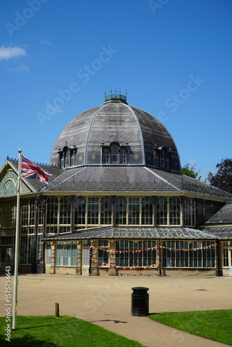 Pavilion Gardens, Buxton, England - July 8 2025: Victorian glass pavilion with domed roof and Union Jack flag.